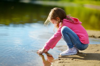 küçük kız bir nehir kenarında oynarken