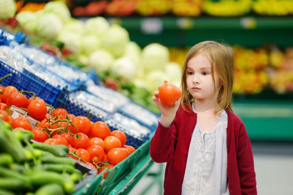Kleines Mädchen bei der Tomatenauswahl — Stockfoto