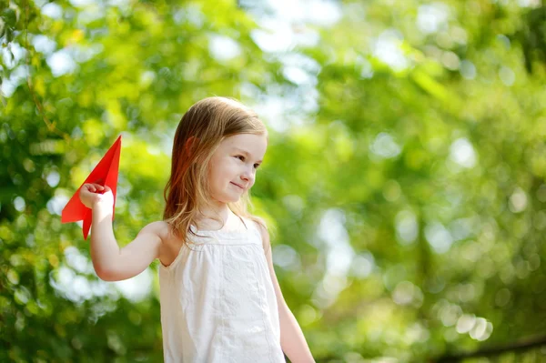 Klein meisje met een papieren vliegtuig — Stockfoto