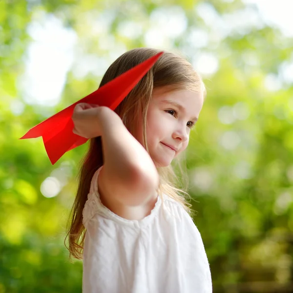 Chica sosteniendo un avión de papel — Foto de Stock