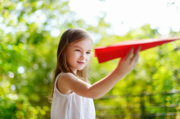 Chica sosteniendo un avión de papel — Foto de Stock
