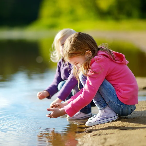 Kleine zusters spelen door een rivier — Stockfoto