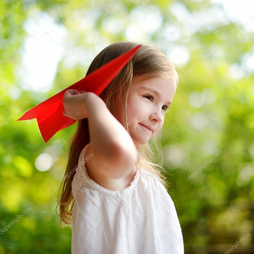 girl holding a paper plane
