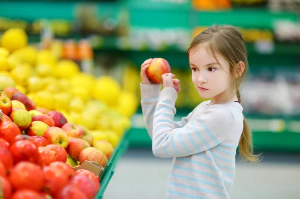 Little girl choosing an apple — Stock Photo, Image