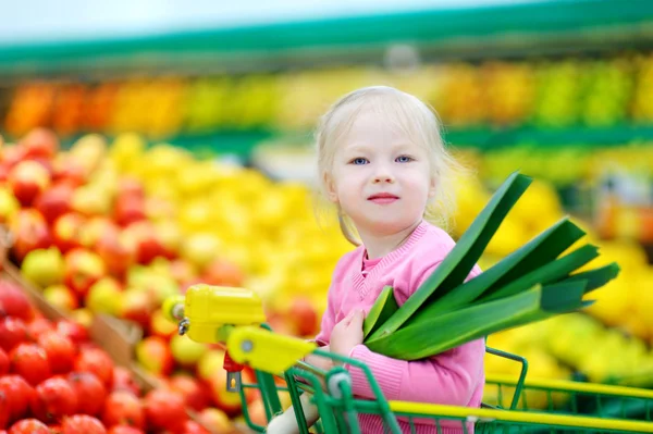 Söt liten flicka anläggning purjolök — Stockfoto