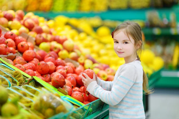 Little girl choosing pomegranate — Stock Photo, Image