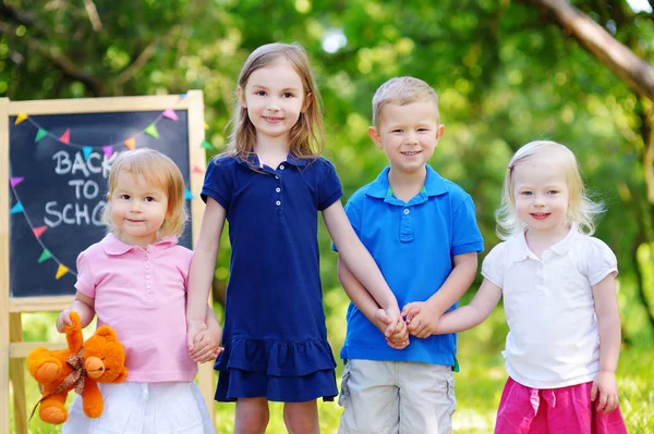 Quattro bambini piccoli in lavagna — Foto Stock