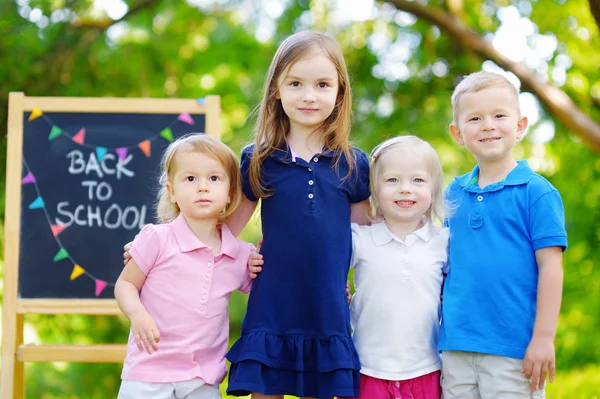 Fyra små barn av svarta tavlan — Stockfoto