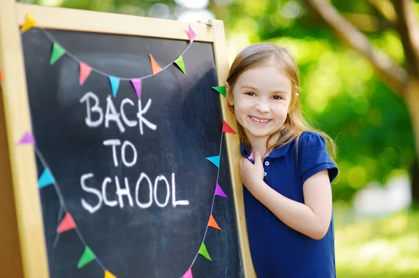 Tjejen kommer tillbaka till skolan Stockbild