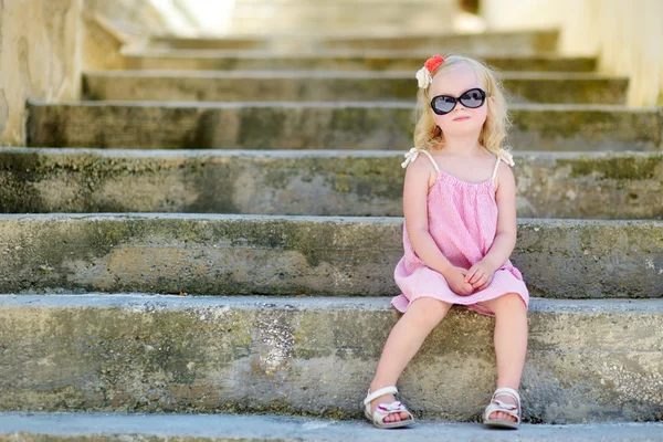 Adorable little girl sitting on stairs — Stock Photo, Image