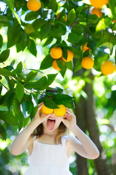 Girl picking fresh ripe oranges — Stock Photo, Image