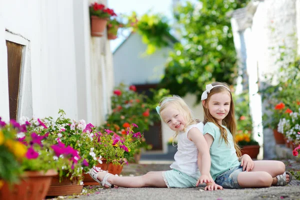 Hermanas sentadas entre flores —  Fotos de Stock