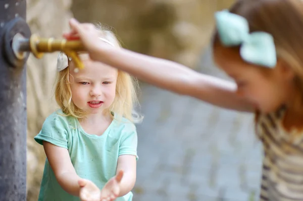 Girls playing with drinking water fountain — Stock Photo, Image