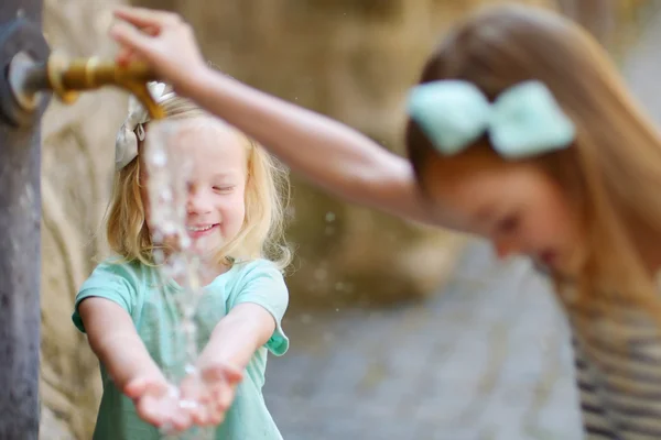 Meisjes spelen met drinkbaar Waterfontein — Stockfoto