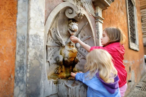 Mädchen spielen mit Trinkwasserbrunnen — Stockfoto