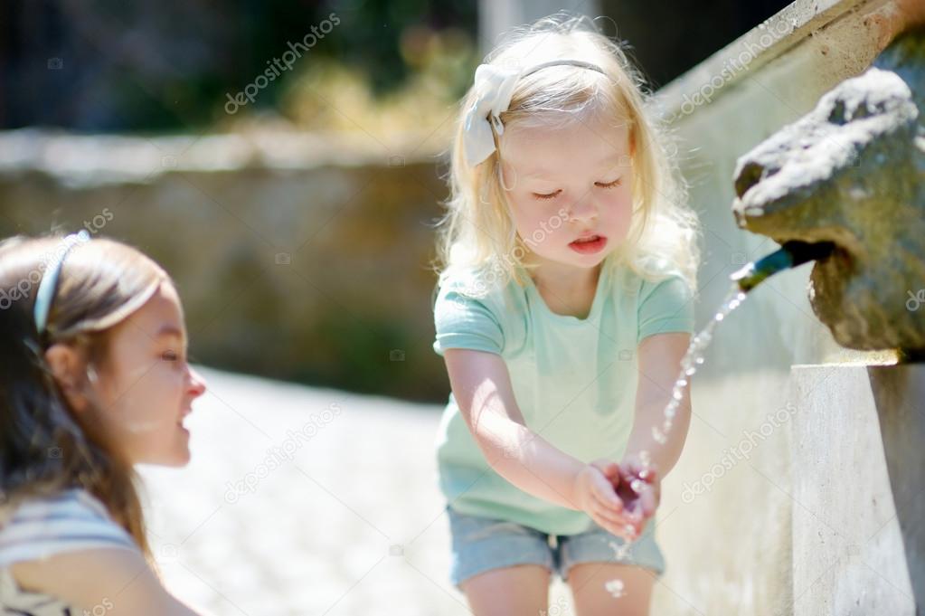 sisters having fun with drinking water fountain