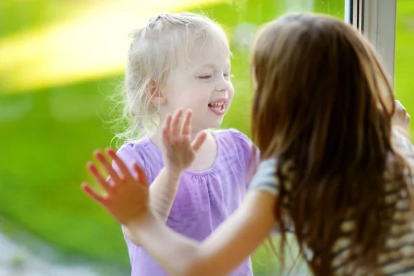 Sisters playnig by a window — Stock Photo, Image