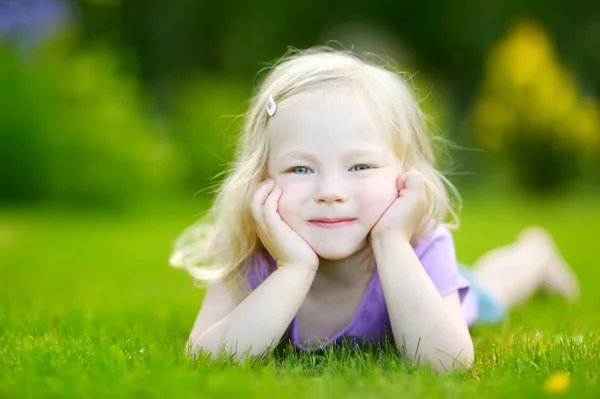 Cute little girl laying in the grass Stock Photo