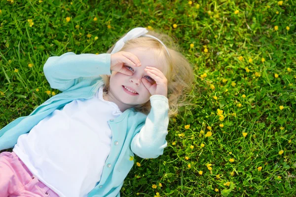 Meisje in het gras te leggen — Stockfoto