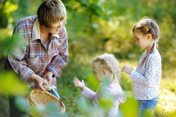 Grandmother and her girls picking mushrooms 