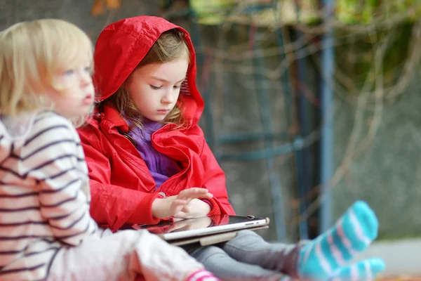 Schwestern spielen mit einem digitalen Tablet — Stockfoto