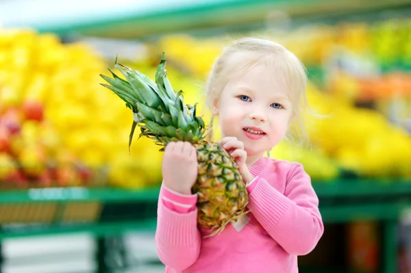 Little girl holding  pineapple — Stock Photo, Image