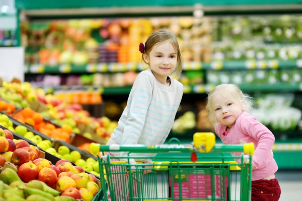 Two little sisters shopping in store — Stock Photo, Image