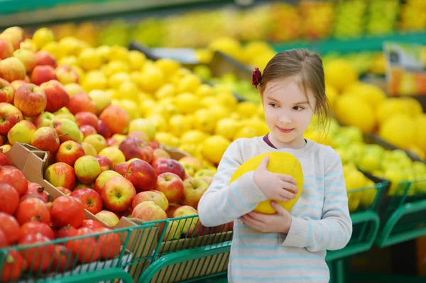 Lilla flickan att välja melon i butik — Stockfoto