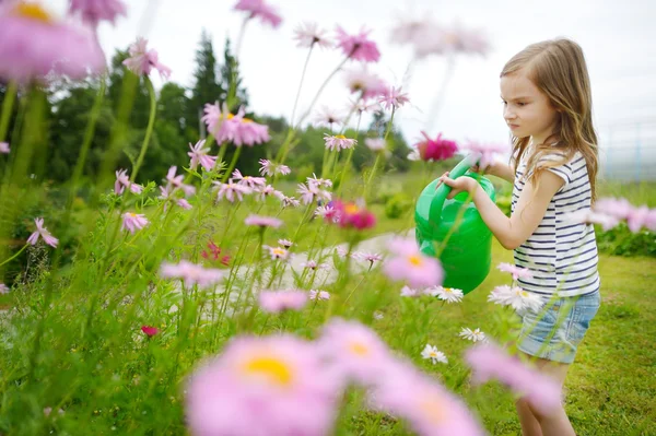 Mädchen gießt Blumen und Pflanzen — Stockfoto
