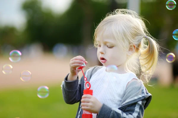 Girl blowing soap bubbles outdoors — Stock Photo, Image