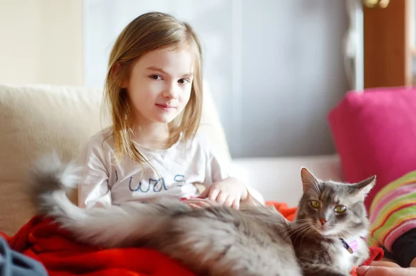 Flicka i pyjamas och hennes katt — Stockfoto