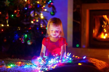 Noel ışıkları ile oynayan kız