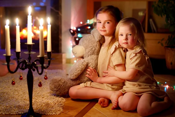 Dziewczyny, siedząc przy kominku w Wigilię Bożego Narodzenia — Zdjęcie stockowe
