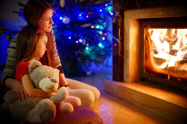 Madre e hija cerca de la chimenea —  Fotos de Stock