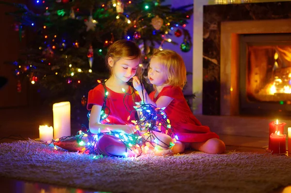 Mädchen spielen mit Weihnachtsbeleuchtung lizenzfreie Stockfotos