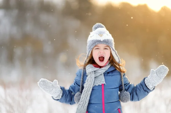 Liten flicka att fånga snöflingor — Stockfoto