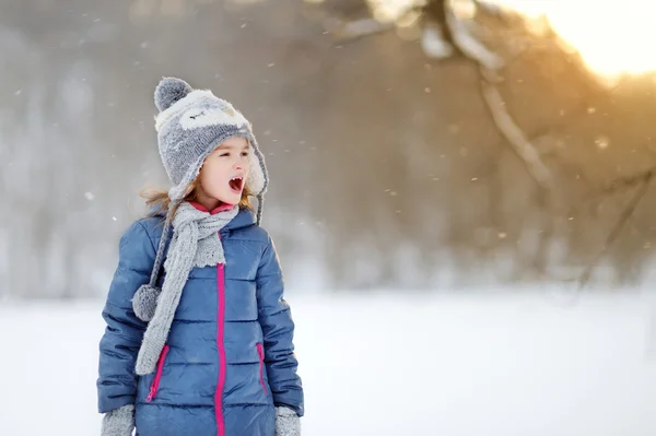 Little girl catching snowflakes — Stock Photo, Image