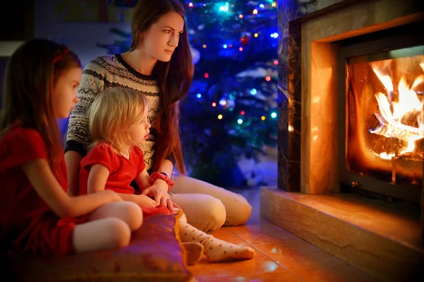 Mother and daughters near fireplace — Stock Photo, Image