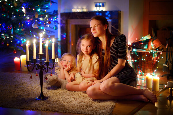 Mother and daughters near fireplace