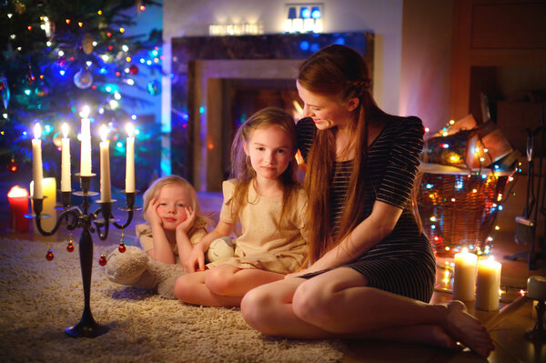 Mother and daughters near fireplace