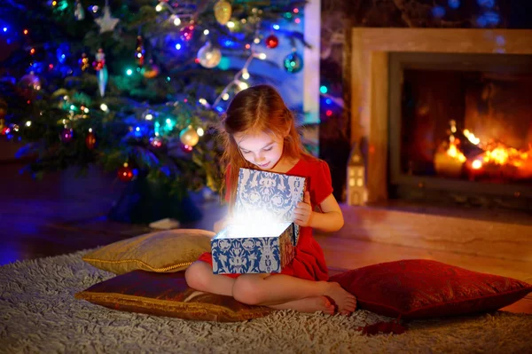 Menina abrindo um presente de Natal mágico — Fotografia de Stock