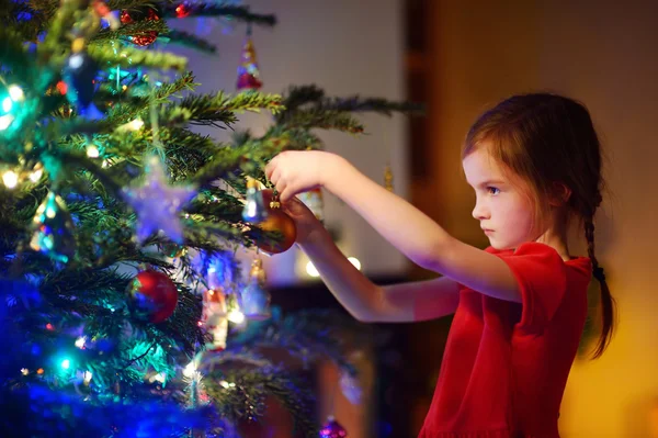 Mädchen schmücken einen Weihnachtsbaum — Stockfoto
