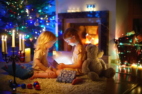 Маленькі дівчата відкривають різдвяний подарунок — стокове фото