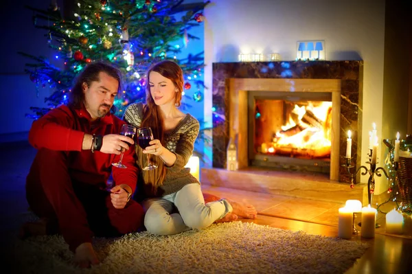 Couple sitting by a fireplace in on Christmas eve — Stock Photo, Image