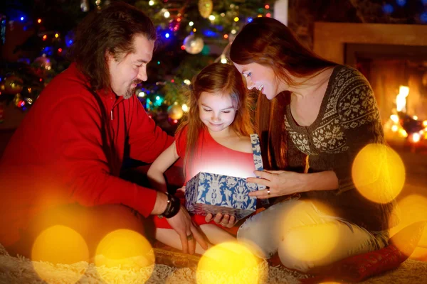 Родители и дочь открывают рождественский подарок — стоковое фото