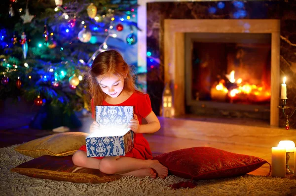 Fille ouvrant un cadeau de Noël magique — Photo