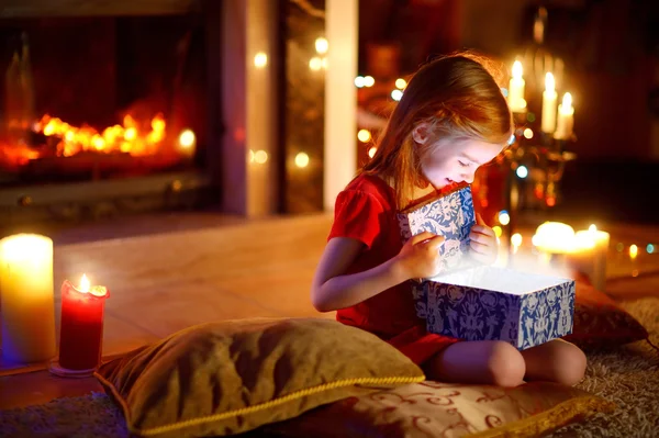Girl opening a magical Christmas gift Royalty Free Stock Photos