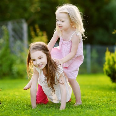 Kız kardeşler çimlere eğleniyor