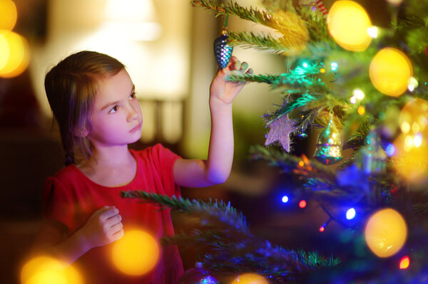 girl decorating a Christmas tree