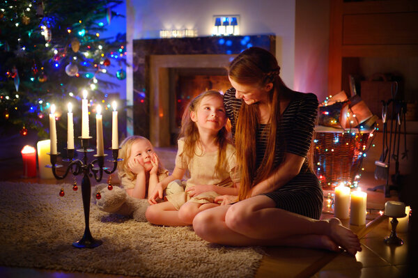 Mother and daughters near fireplace